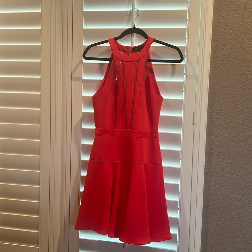 Orange/red short dress, accented darts flowing into a cinched waist band.
